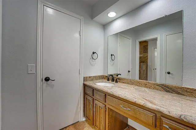a bathroom with a granite countertop sink and a mirror