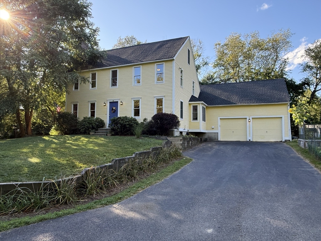 291 Harvard Road Bolton, MA 01740 - Photo 1 of 40 a front view of a house with a yard and garage