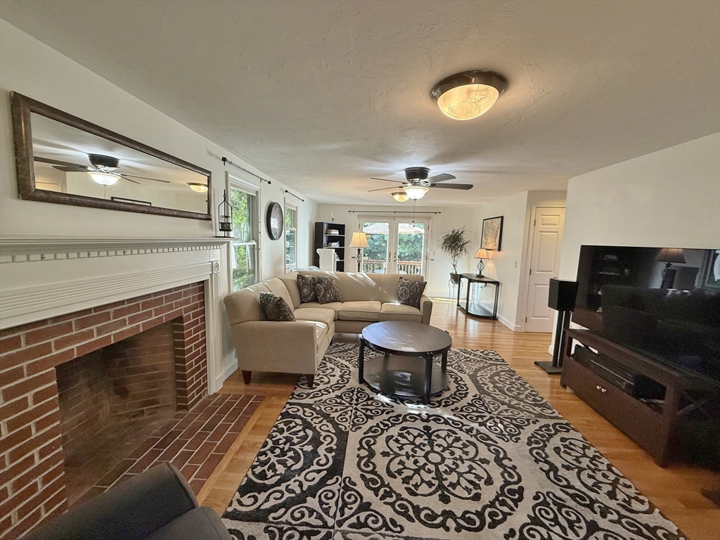 291 Harvard Road Bolton, MA 01740 - Photo 11 of 40 a living room with furniture a fireplace and a flat screen tv