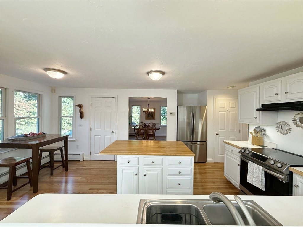 291 Harvard Road Bolton, MA 01740 - Photo 22 of 40 a large kitchen with kitchen island a stove a sink dishwasher and cabinets with wooden floor