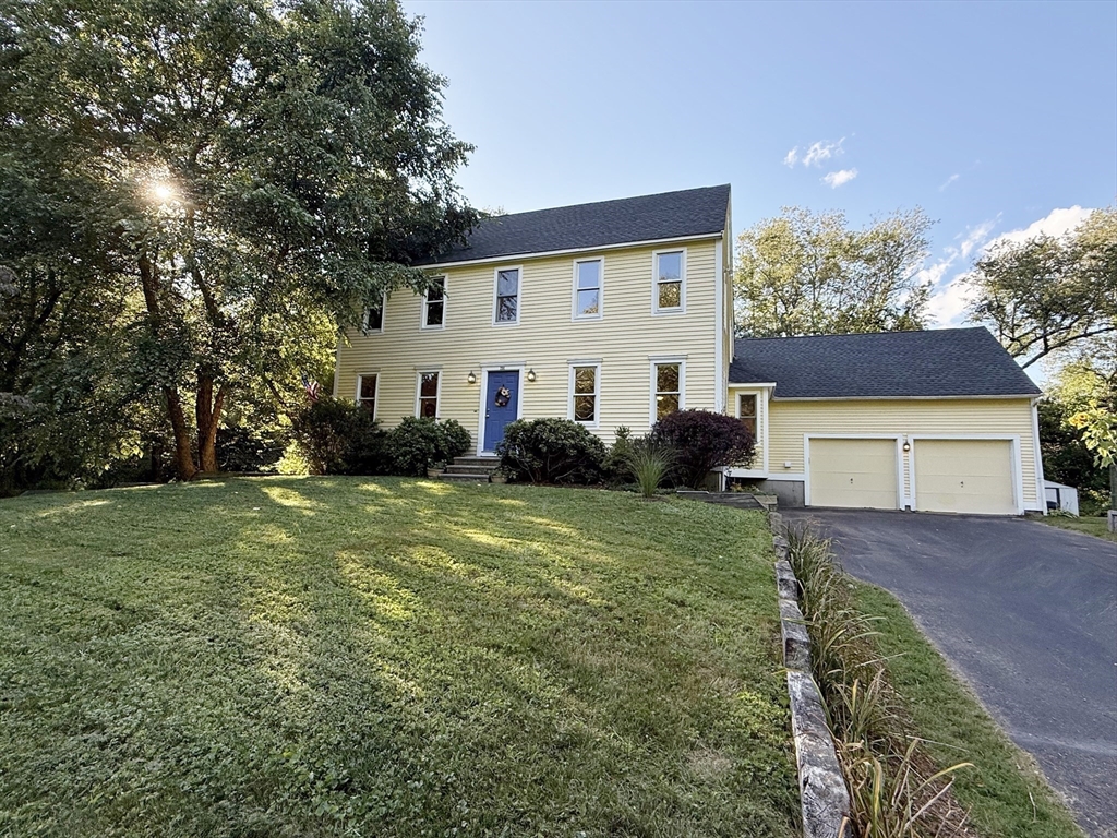 291 Harvard Road Bolton, MA 01740 - Photo 3 of 40 a front view of house with yard and trees in the background