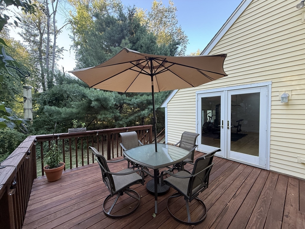 291 Harvard Road Bolton, MA 01740 - Photo 32 of 40 a patio with wooden floor and outdoor seating