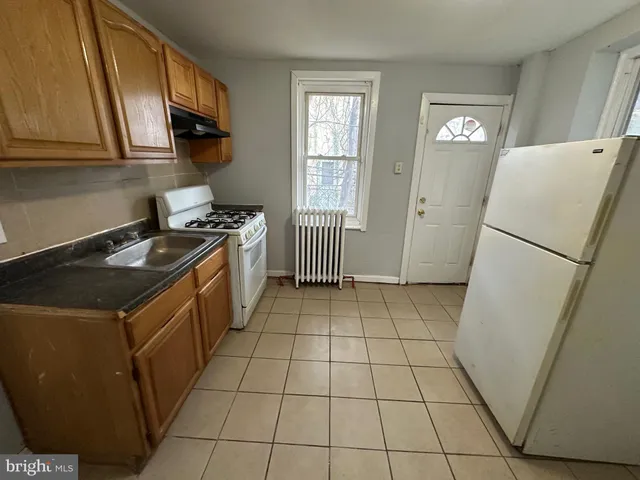 a kitchen with a sink a stove a refrigerator and cabinets