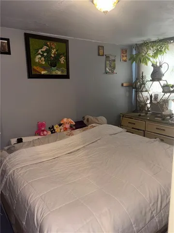 a bedroom with a bed and a painting on the wall
