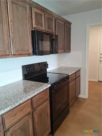 a kitchen with granite countertop cabinets and steel stainless steel appliances