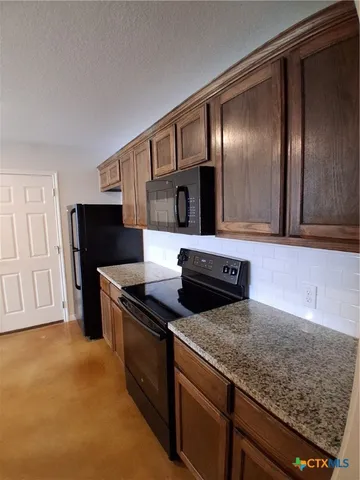 a kitchen with granite countertop stainless steel appliances and wooden cabinets