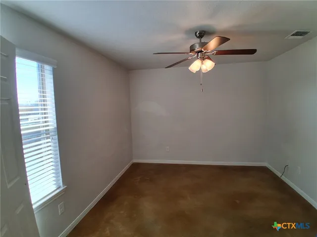 a view of a room with a ceiling fan and a window