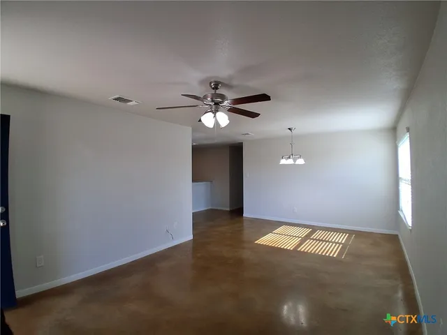 a view of an empty room with a ceiling fan