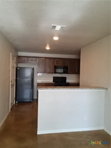 a kitchen with stainless steel appliances a refrigerator and a stove top oven
