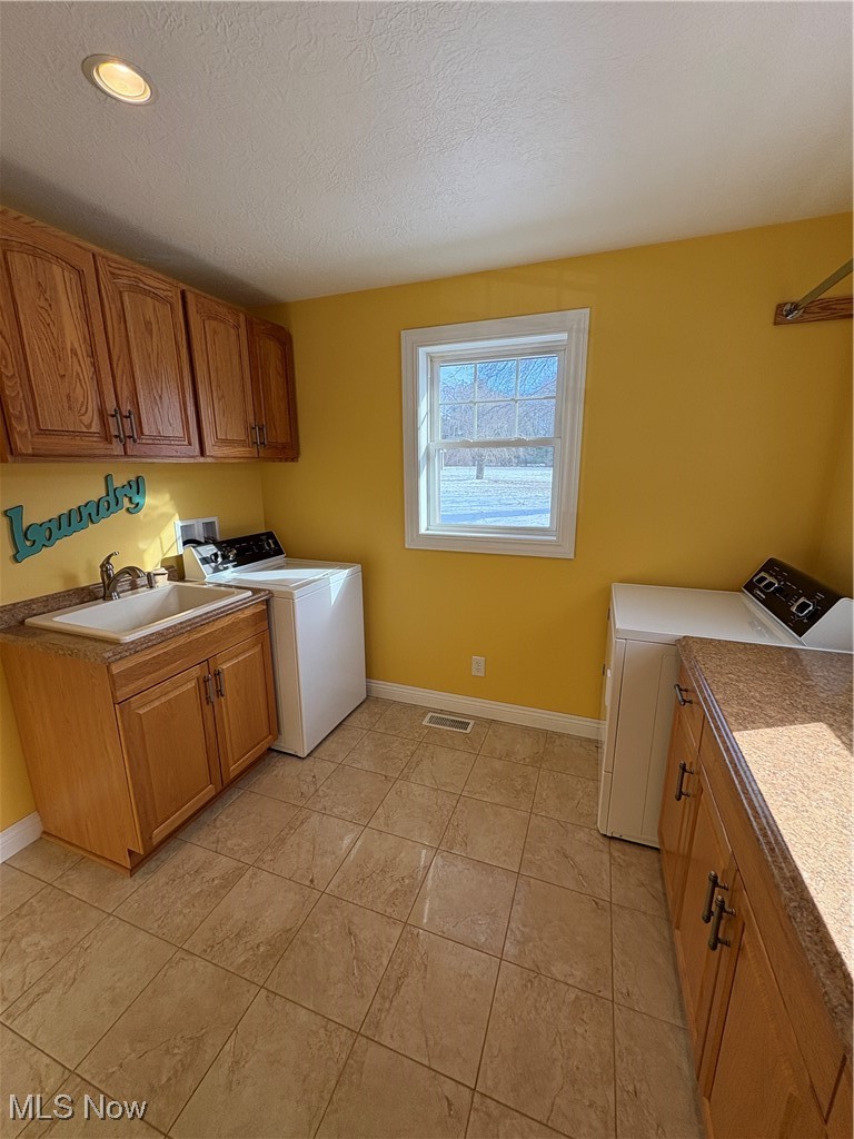 2504 Meloy Road Kent, OH 44240 - Photo 42 of 50 Clothes washing area featuring cabinets, a textured ceiling, sink and light tile patterned flooring