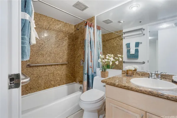a bathroom with a granite countertop sink toilet and shower