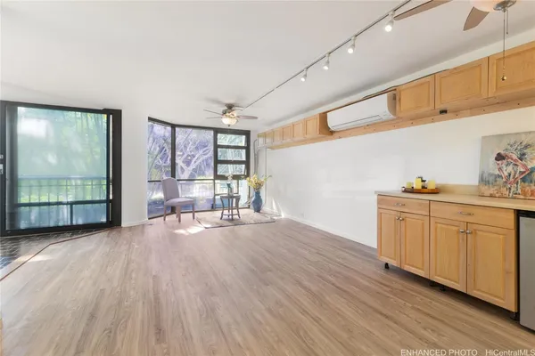 a furnished livingroom with windows and wooden floor