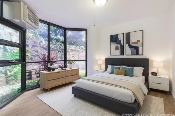 a bedroom with furniture and large windows