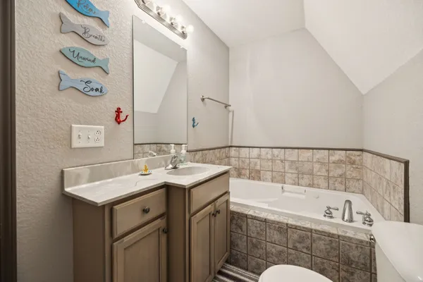 a bathroom with a tub sink and mirror