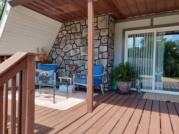 a balcony with chairs and wooden floor