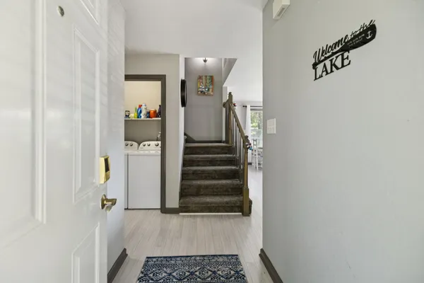 a view of a hallway with stairs and wooden floor