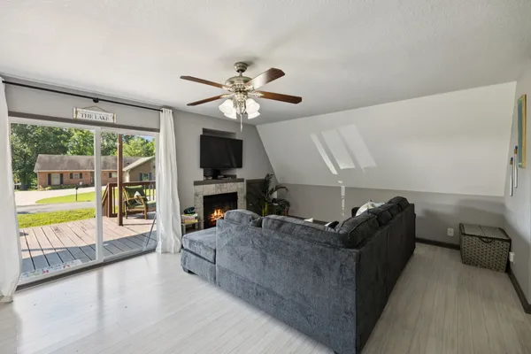 a living room with furniture a flat screen tv and a fireplace