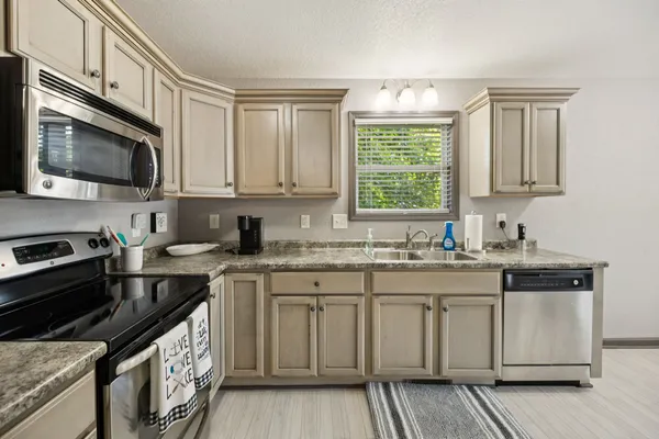 a kitchen with stainless steel appliances granite countertop a stove a sink and a microwave