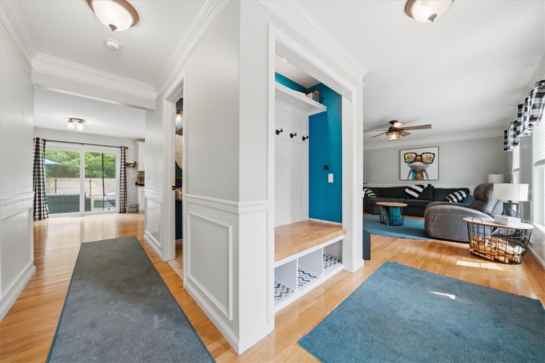 26 Davis Circle Warwick, RI 02886 - Photo 6 of 50 Custom-built entry drop zone with bench seating, shaker-style paneling, multiple coat hooks, upper shelf, and storage cubbies below—keeping everyday essentials organized while creating a warm and welcoming first impression.