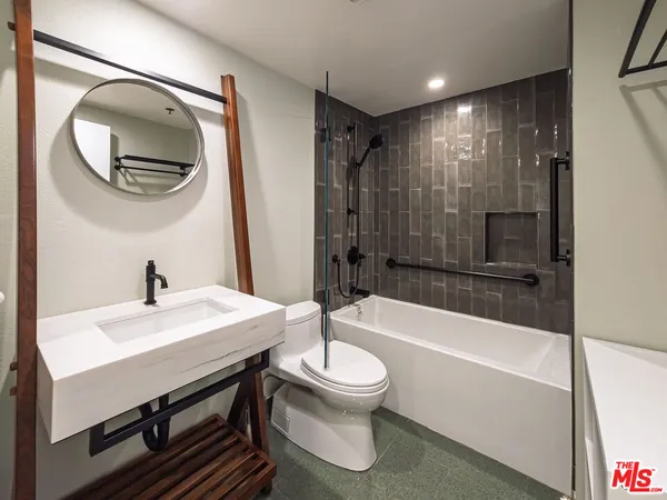 a bathroom with a sink a toilet and a mirror