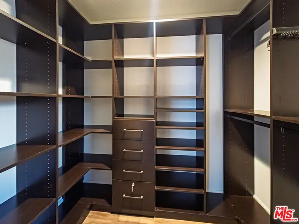 a view of walk in closet with empty racks