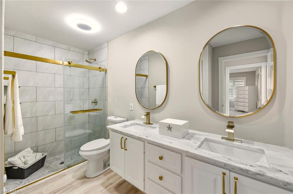 3408 Cayman Lane Naples, FL 34119 - Photo 16 of 34 a bathroom with a toilet a sink and mirror