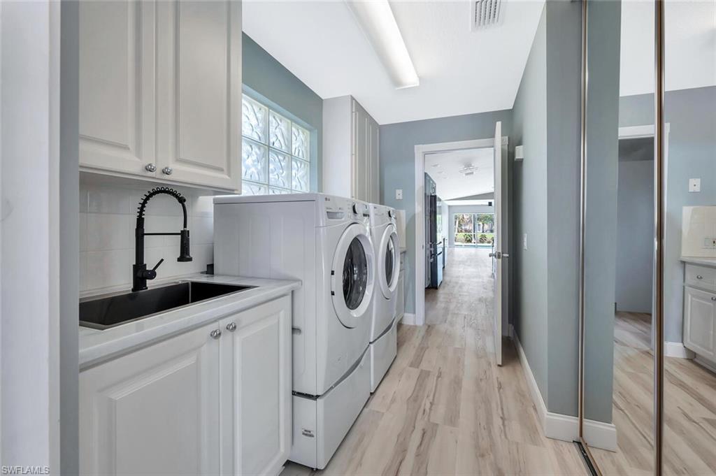 3408 Cayman Lane Naples, FL 34119 - Photo 21 of 34 a kitchen with white cabinets and sink