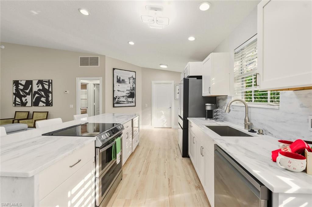 3408 Cayman Lane Naples, FL 34119 - Photo 4 of 34 a kitchen with a sink stove and cabinets