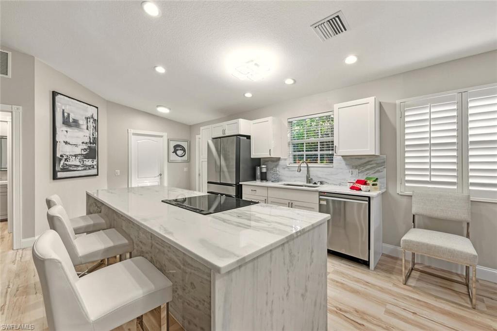 3408 Cayman Lane Naples, FL 34119 - Photo 5 of 34 a kitchen with a sink cabinets and wooden floor
