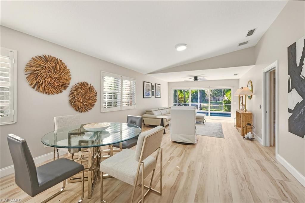 3408 Cayman Lane Naples, FL 34119 - Photo 10 of 34 a dining room with furniture a window and wooden floor