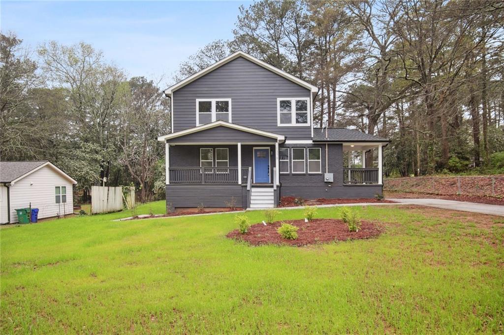 a front view of a house with a yard and trees