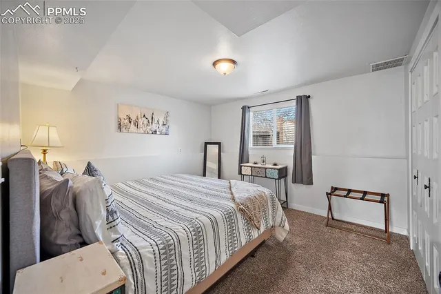 a bedroom with a bed and a painting on the wall