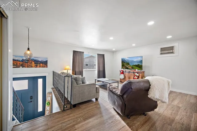 a living room with furniture and a wooden floor