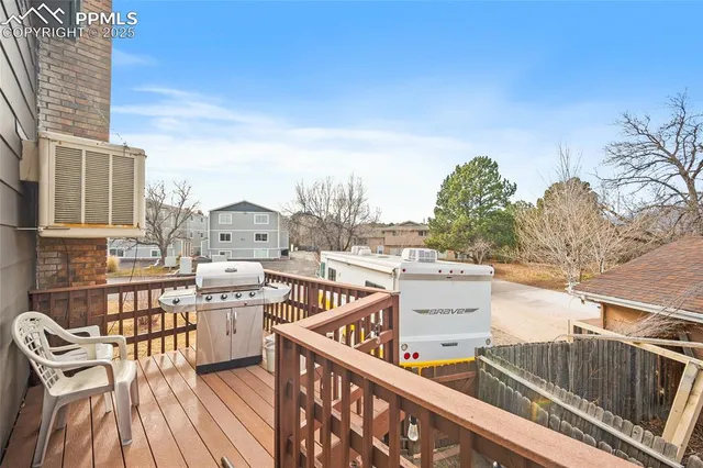 a view of a balcony with wooden floor and iron fence