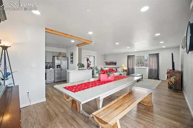 a living room with a couch and kitchen view with wooden floor