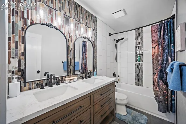 a bathroom with a double vanity sink mirror and toilet