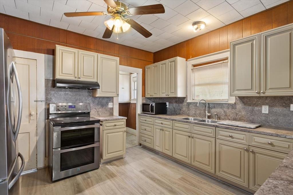 4246 Old Caufield Ranch Road McGregor, TX 76657 - Photo 9 of 31 Double electric oven, stainless steel refrigerator, and built in cream colored cabinets