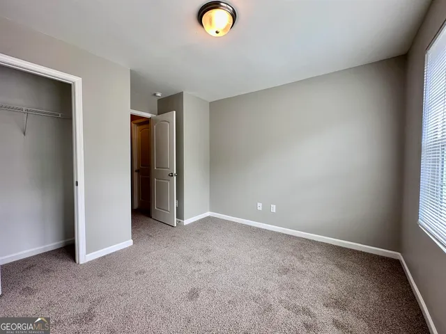 an empty room with closet and windows