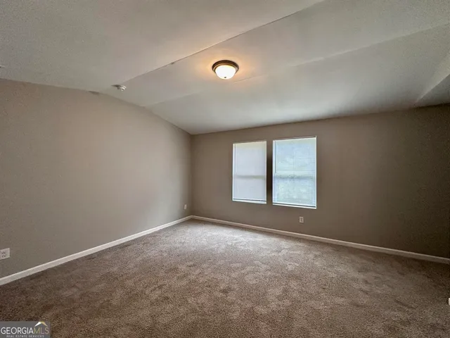 an empty room with a empty space and windows