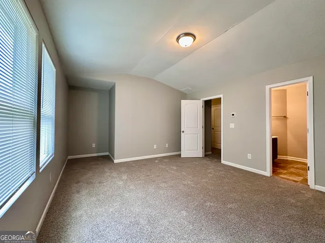 an empty room with closet and a bathroom