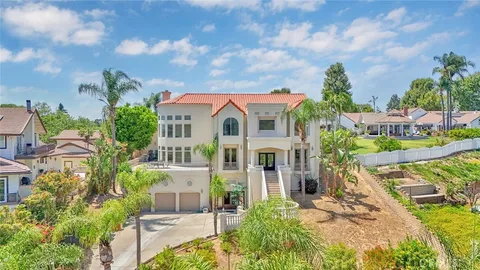 a front view of a house with a garden and trees