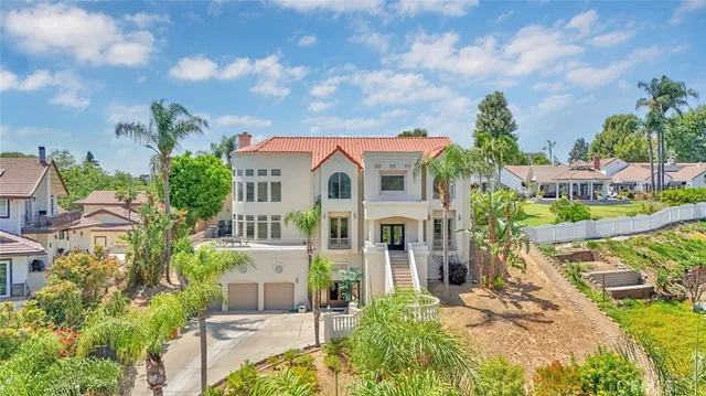 a front view of a house with a garden and trees