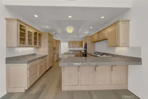 a large kitchen with stainless steel appliances granite countertop a large counter top a stove and a sink