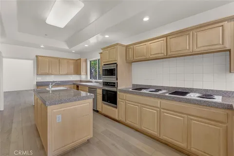 a kitchen with granite countertop cabinets stainless steel appliances and a counter space
