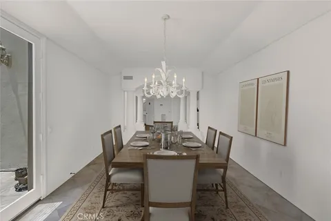 a view of a dining room with furniture a chandelier and wooden floor