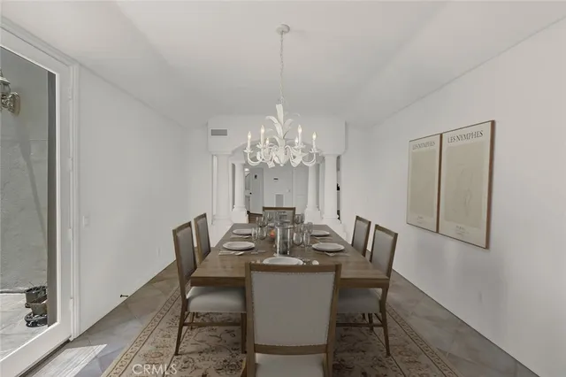 a view of a dining room with furniture a chandelier and wooden floor