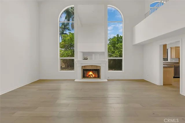 an empty room with windows and fireplace
