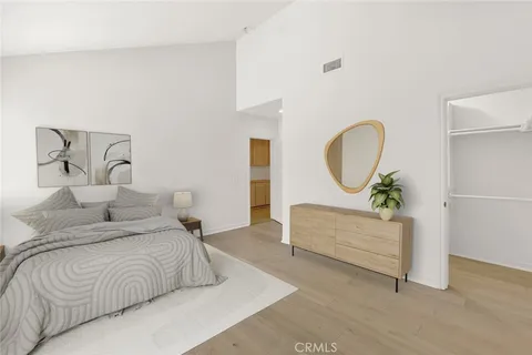 a bedroom with a bed mirror and a potted plant