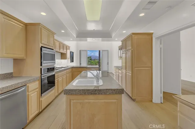 a large kitchen with stainless steel appliances granite countertop a refrigerator a oven a sink and a granite countertops