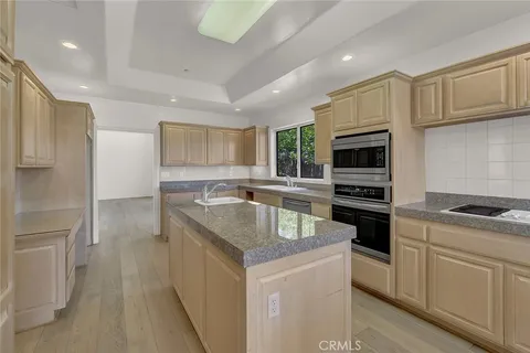 a kitchen with granite countertop a sink stove and refrigerator